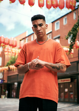 portrait of a man in a orange tee shirt in china town