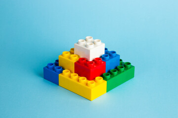 Color plastic building blocks on red background