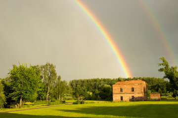 Double rainbow in the sky over the summer park.