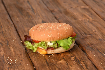 Tasty hamburger on a wooden table.