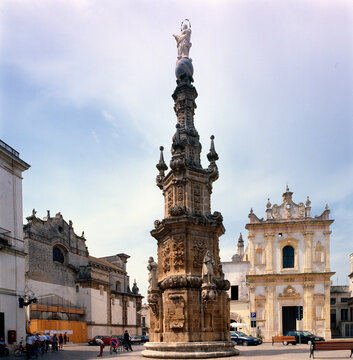 Nard&ograve;, Lecce. Guglia dell'Immacolata in Piazza Salandra con la chiesa di San Tritone.