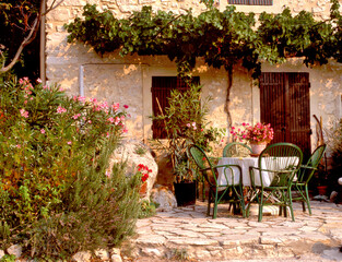 A quaint, pretty garden scene, with rustic patio furniture