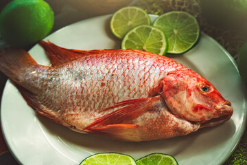 Fresh sea fish accompanied by lemons on a plate