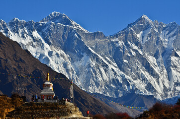 Trekkers stop by a buddhist stupa to rest and enjoy the view of Mount Everest (8.848m) and Lhotse (8.516m) on the way to its Base Camp, Sagarmatha National Park, Solukhumbu, Nepal 