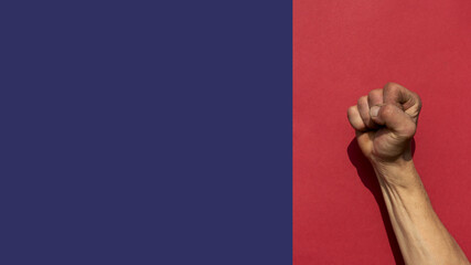 Swarthy rough mans hand with lenched fist on red background. Cesar Chavez Day concept.