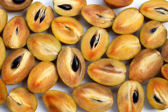 Fresh half sapodilla fruits isolated on white