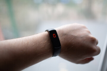 Male hand with fitness tracker with low charge battery symbol