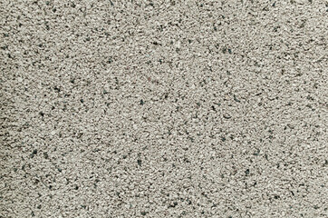Decor made of small black and white granite chips on the facade of a house or a fence. Background for the design of exterior walls.