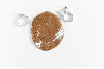 Raw easter gingerbread dough with cutters and flour. Preparation of Easter cookies. White background