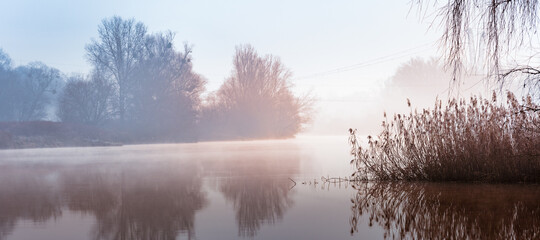 A cold morning on the Odra River in Wroclaw, a delicate fog rises above the water.