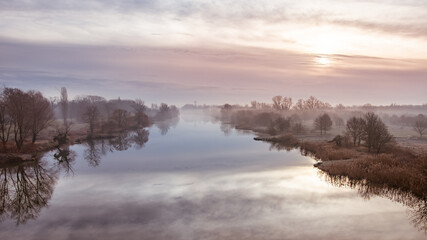 A cold morning on the Odra River in Wroclaw, a delicate fog rises above the water.