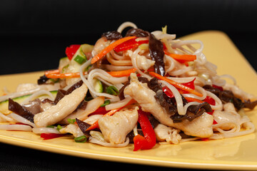 rice noodles with vegetables on a flat plate