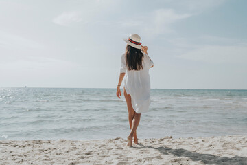 Fototapeta na wymiar Woman by the sea. Look to the horizon. Sun, sea, summer, sandy beach, rest, vacation.