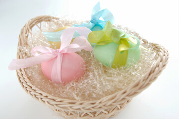 straw basket with colored and decorated eggs for easter breakfast in italy on white background