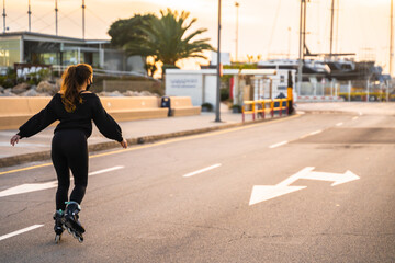 Caucasian girl with mask skating on roller skates on the promenade of Palma de Mallorca at a beautiful sunset, Spain (Perfect for copyspace) © Alberto