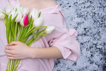 girl in a pink blouse holding white tulips