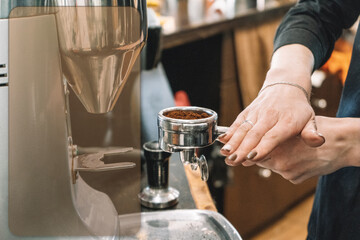 Fototapeta na wymiar The barista temps the coffee before brewing a great fragrant, fresh espresso