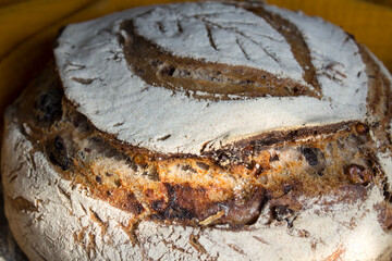 Crusty bread on a yellow kitchen towel. Top view photo of fresh baked sourdough bread.  Still life food.