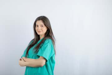 Young nurse crossed her hand and looking at camera