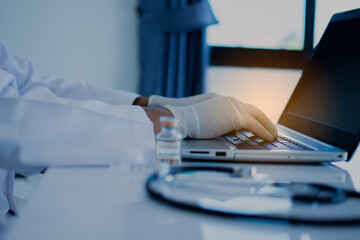 A doctor typing the data and description into a server computer with a laptop. A concept invented a...