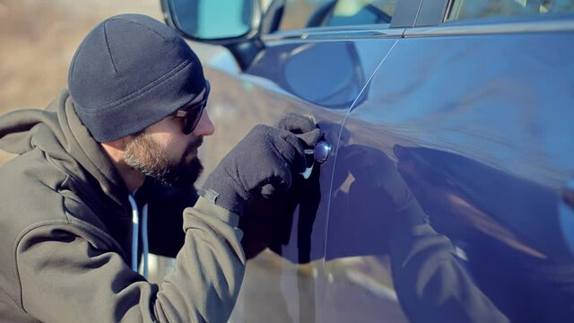 Vandalism Crime Theft Using Tool For Open Door.Thief Breaks Lock On Vehicle. Car Jacking Thief Steal Car Breaking Door. Criminal Bandit Job Burglar Hijacks Auto.Street Crime Violence Gangster Robber. 