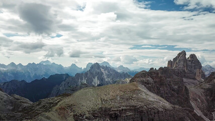 Fototapeta premium A panoramic view on Italian Dolomites. There are many high and sharp peak in front, with many landslides. Dangerous climbing. Barely any plants growing in the area. Raw and unspoiled landscape.