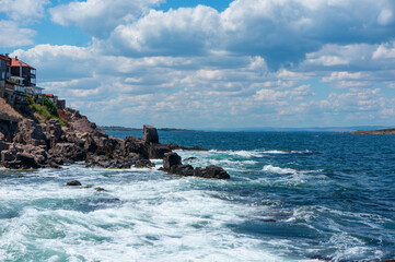Sea surf day landscape. Sea waves with white foam breaks on stones. Sozopol. Bulgaria