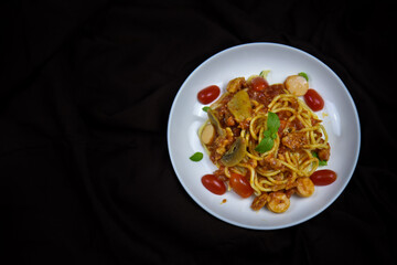 Delicious classic Italian spaghetti with tomato sauce, Parmesan cheese and mint leaves on a plate. There is a writing area.
