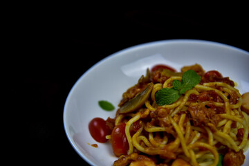 Delicious classic Italian spaghetti with tomato sauce, Parmesan cheese and mint leaves on a plate. There is a writing area.