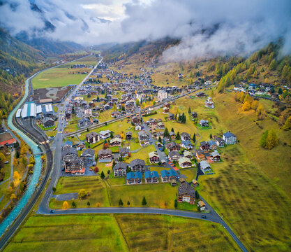 Aerial view of a waving road in countryside going to Ardon township with mountain range in background, Ardon, Switzerland.