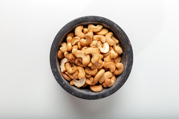 Cashew fruit in black marble pestle on white background. Top view.