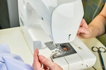 Female hands doing maintenance work on a domestic sewing machine