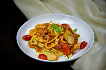 Delicious classic Italian spaghetti with tomato sauce, Parmesan cheese and mint leaves on a plate. There is a writing area.