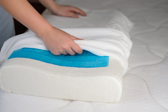 Women's hands put a cover on the orthopedic pillow with cooling gel. Protecting the foam pillow from moisture