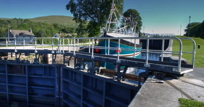 Timelapse of pleasure boat travelling through the series of locks comprising the Neptune Staircase on the Caledonian Canal in Banavie towards Loch Eil, Fort William, Scotland