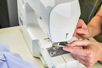 Female hands doing maintenance work on a domestic sewing machine
