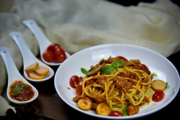Delicious classic Italian spaghetti with tomato sauce, Parmesan cheese and mint leaves on a plate. There is a writing area.