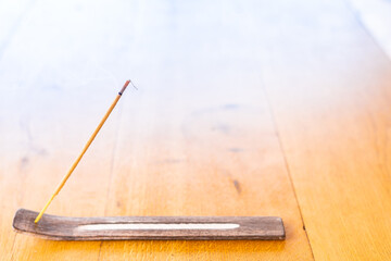 An aromatic relaxing mosquito stick stands on a stand on the terrace table and smokes