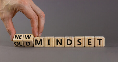 New vs old mindset symbol. Businessman turns the wooden cube and changes words 'old mindset' to 'new mindset'. Beautiful grey background. Business, new or old mindset concept. Copy space.