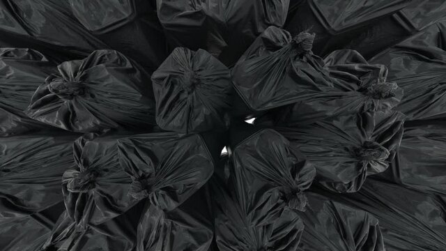 Black garbage bags filled the white space. The bags are tied with knots that stretch upward. Slow motion.