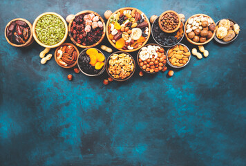 Fototapeta na wymiar Nuts and dried fruits. Dried apricots, figs, prunes, raisins, cranberries, pecans, walnuts, pistachios, cashews, hazelnuts, almonds and other. Food background, top view