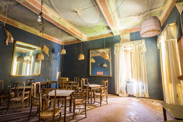 Fototapeta na wymiar Stanza con pareti blu, tavoli e sedie