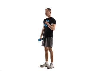 Dumbbells. Young caucasian male model in action, motion isolated on white background with copyspace. Concept of sport, movement, energy and dynamic, healthy lifestyle. Training, practicing. Authentic.