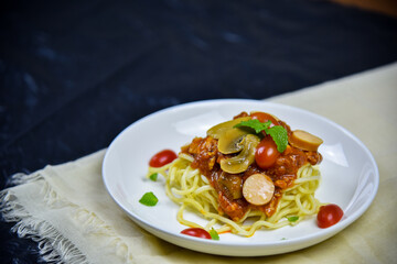 Delicious classic Italian spaghetti with tomato sauce, Parmesan cheese and mint leaves on a plate. There is a writing area.