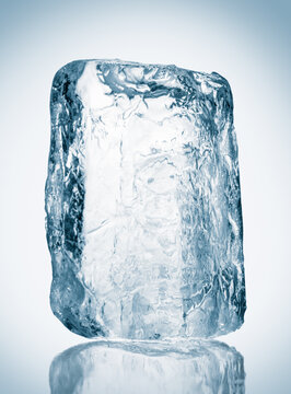 Block of textured clear blue ice on reflective surface. Clipping path included.