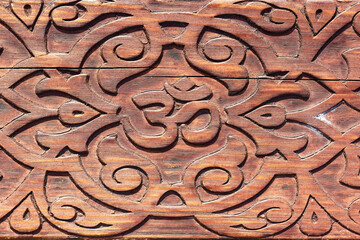 OM sign carved with a pattern on a wooden bench
