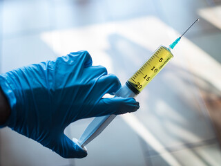 Detail of vaccine with gloves and syringe