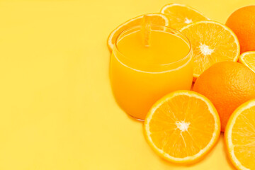Fresh orange juice in glass with fruits, isolated on yellow. 