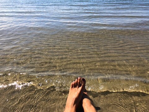 Woman's feet at water's edge by the sea, Fanoe, Jutland, Denmark
