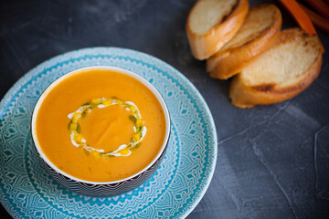Pumpkin carrot cream soup with bright spices and croutons